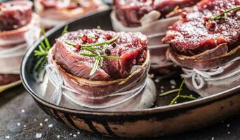 Beef tenderloin steak wrapped in bacon stored into the pan photo
