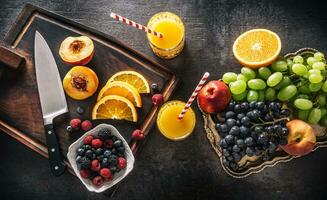 Top of view fresh fruits juice orange grapes peach berries on concrete table photo