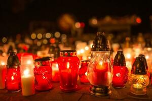 muchos ardiente velas en el cementerio a noche en el ocasión almas de el fallecido foto