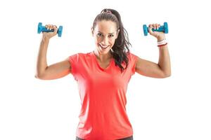 Woman working oyt with hand weights holding them up to exercise shoulders photo