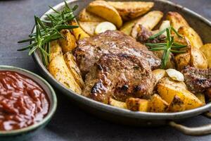 Beef grilled steaks with barbecue sauce roasted potatoes and rosemary photo