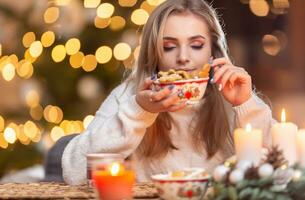 un hermosa joven rubia mujer sabores Fresco Navidad pan de jengibre con genial gusto foto