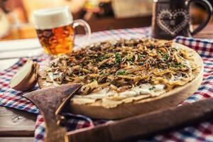 tradicional eslovaco patata tortita con frito cebolla tocino y queso bryndza con sequía cerveza foto