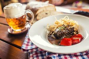 confitar carne de vaca filete con salsa frito cebolla un pan sequía cerveza y decoración en pub o restaurante foto