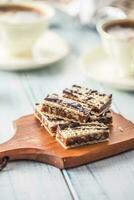 A waffle cake with caramel chocolate and walnuts.Traditional slovak and czech cake grilaz with coffee photo