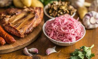 Sour cabbage dried mushrooms smoked pork ribs sausages garlic potatoes and celery herbs photo