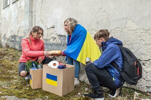 vysne nemecke, Eslovaquia. marzo 30 2022. mamá y su niños compartir un pan desde un paquete de humanitario ayuda ese llegado en Ucrania foto