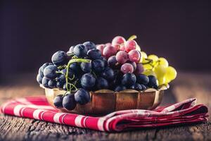 Grape. Bunch of multicolored grapes in retro bowl on old oak table photo