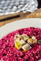 Plate of tasty beetroot risotto with cheese and aperitif photo