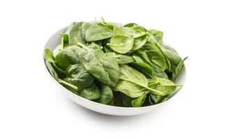 Spinach. Fresh baby spinach leaves in plate isolated on white photo