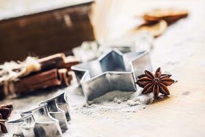 Star anise cookie cutter cinnamon and flour on baking board. Christmas baking utensil and holiday concept photo