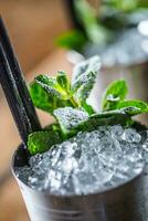 Mint julep cocktail alcoholic drink on wooden board in pub or restaurant photo