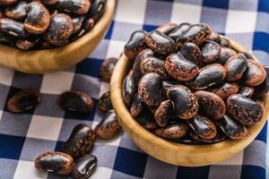 Uncooked beans in wooden bowles on kitchen table. photo