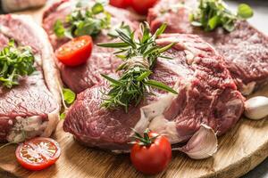 Beef ribe eye steaks with rosemary oregano and tomatoes photo