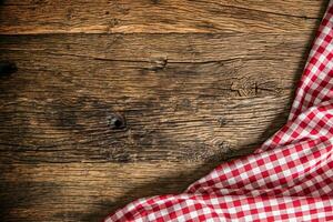 Red checkered kitchen tablecloth on rustic wooden table photo