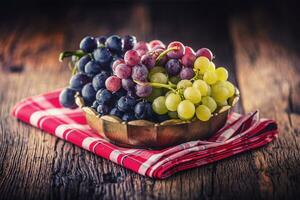 Grape. Bunch of multicolored grapes in retro bowl on old oak table photo