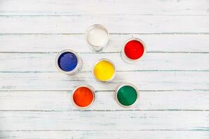 Top of view full of multicolored paint cans on table photo