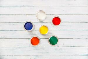 Top of view full of multicolored paint cans on table photo