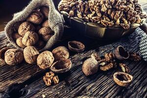 Walnut kernels whole walnuts in burlap sack and vintage bowl photo
