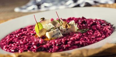 Plate of tasty beetroot risotto with cheese and aperitif photo