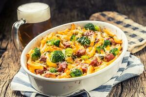 Baked pasta penne with broccoli smoked pork neck mozzarela cheese and othe ingredients photo