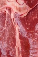 crudo Fresco jugoso carne de vaca t-bone filete con sal, especias y hierbas foto