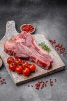 Raw fresh juicy beef t-bone steak with salt, spices and herbs photo