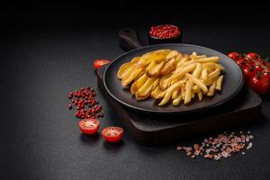 Delicious crispy french fries with salt and spices on a textured concrete background photo