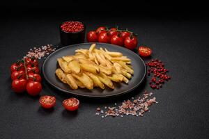 Delicious crispy french fries with salt and spices on a textured concrete background photo