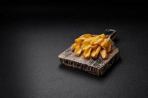 Delicious crispy potato deeps with salt and spices on a textured concrete background photo