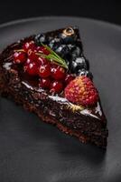 Delicious sweet chocolate brownie cake with blueberries, currants and raspberries photo