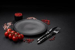 Empty black plate over dark stone background with copy space photo