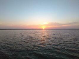 Twilight rays and clouds reflected in the calm water. photo