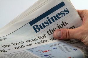 Investor holding and reading business latest newspaper photo