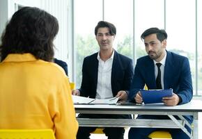 Job interview concept. Diverse hr team doing job interview with a woman in business office. Human resources team interviewing a potential job candidate. Hiring, employment, and recruitment concept. photo