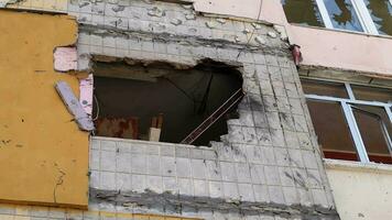 huellas de un artillería cáscara golpear un de muchos pisos residencial edificio. parte de el edificio estaba destruido por el conmoción ola y metralla. bombardeo a hogar. video