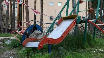 War in Ukraine. Destroyed playground in the city center. The ruins of a high-rise building destroyed by a Russian missile a year after the occupation. video
