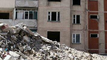 Bagger mit hydraulisch Brecher beim das Abriss von ein Wohn Gebäude. Stadt Erneuerung. Abbau, Zerstörung von ein Hochhaus mehrstöckig Gebäude zum Wiederaufbau. Trümmer Clearing. video