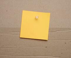 Yellow paper blank stickers attached with a button, space for notes and labels photo
