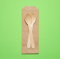 Wooden spoons on a green background, top view photo