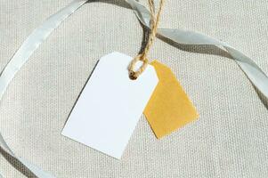 Two rectangular tags with a rope on a gray fabric. empty label mockup template to place your design. photo