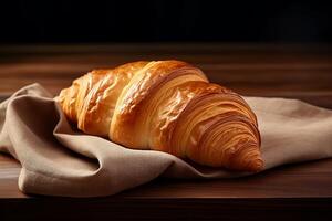 A crispy croissant is lying and a towel. photo