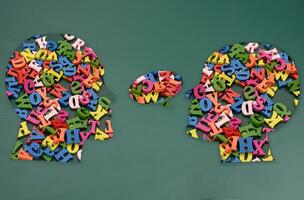 Two silhouettes of human heads with colorful letters, concept of conversation, intellectual discussion photo