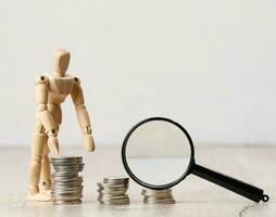 Wooden dummy and stacks of white coins, the concept of accumulation of cash, donation, subsidy photo