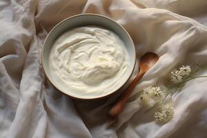 Thick, greasy sour cream in a deep dish with a wooden spoon. photo