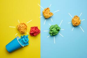 The concept of inspiration with new ideas, the search for creative solutions, crumpled sheets of paper in the form of balls on a blue yellow background photo