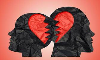 Silhouettes of female and male heads cut out of paper and a torn heart, symbolizing the concept of unhappy love photo