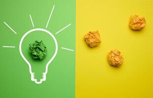 The concept of inspiration with new ideas, the search for creative solutions, crumpled sheets of paper in the form of balls on a green yellow background photo
