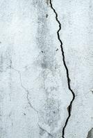 Close-up of Cracked concrete wall texture, Cement background not painted in vintage style for graphic design or retro wallpaper,texture crack in concrete wall photo