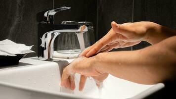 Man's hand is pouring in the sink in one of the luxury bathrooms on the property. photo